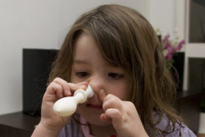 Use of the otovent device. A nozzle is placed into one nostril while the other is occluded. Then an attempt is made to inflate the balloon, which provides a safe level of resistance. Most 3-4 year olds can use this device.